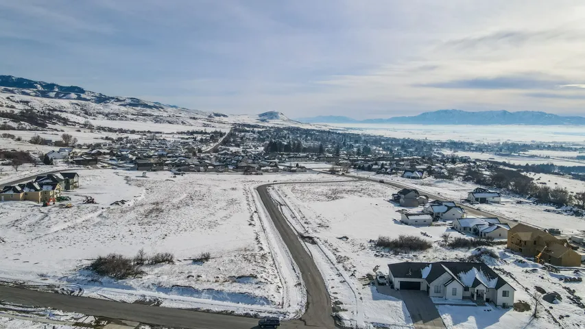 Snowy aerial view with a mountain view and a residential view