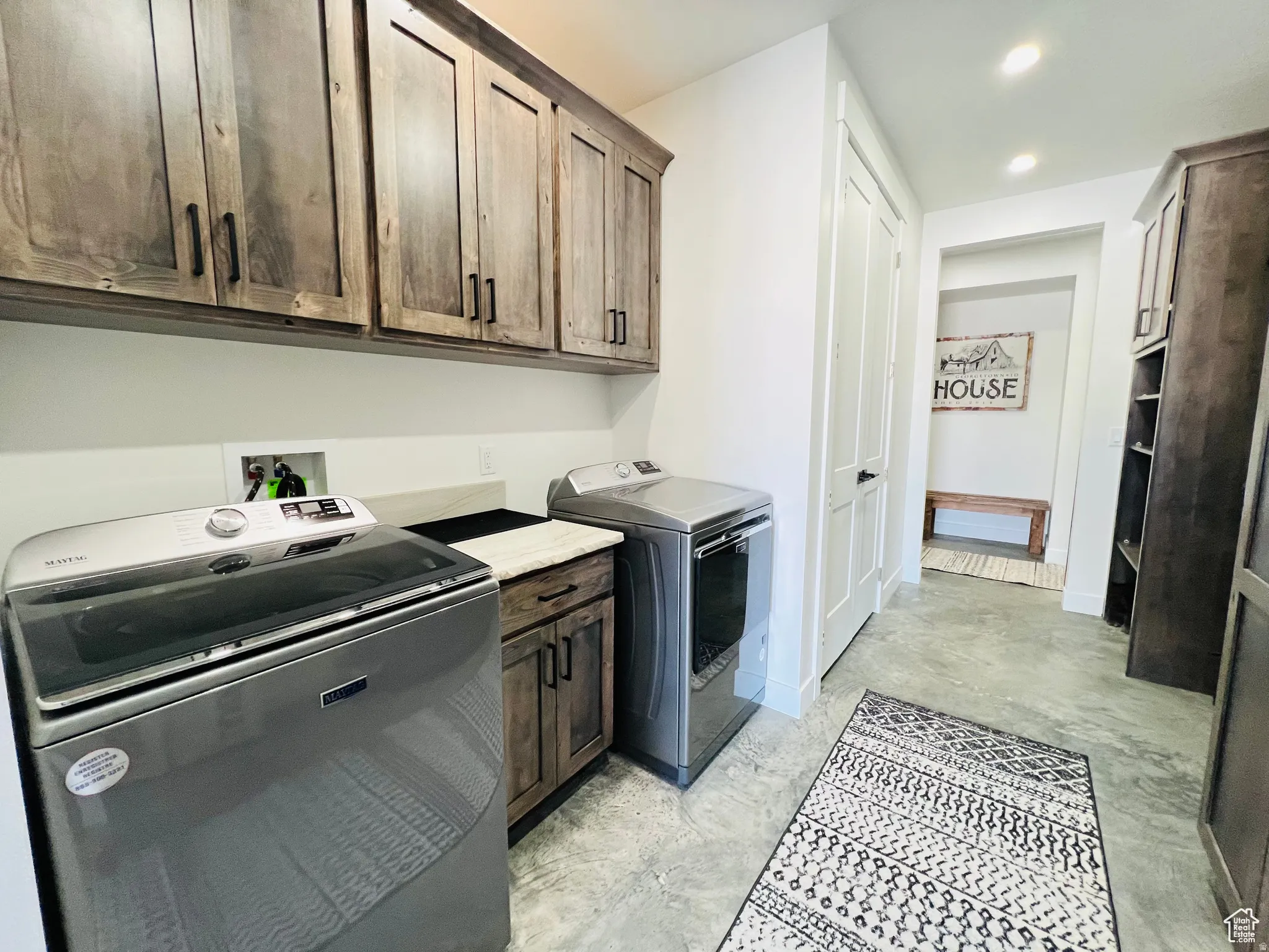 Laundry room featuring separate washer and dryer, recessed lighting, and cabinet space
