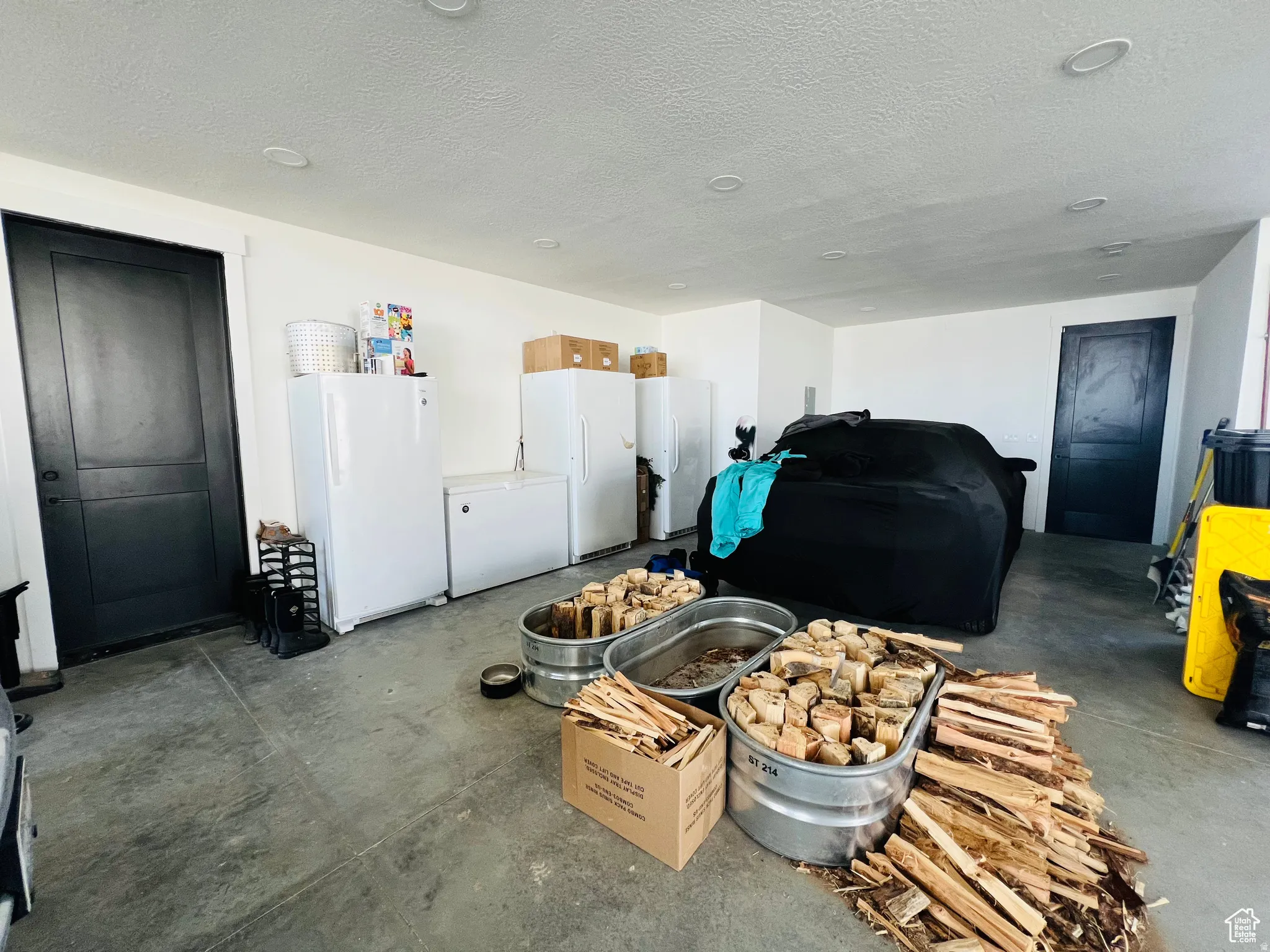 Garage with freestanding refrigerator and white fridge