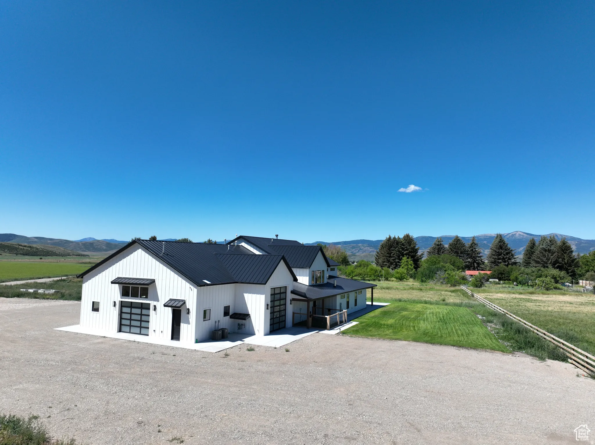 View of front of home with a view of countryside, a mountain view, board and batten siding, a metal roof, and driveway