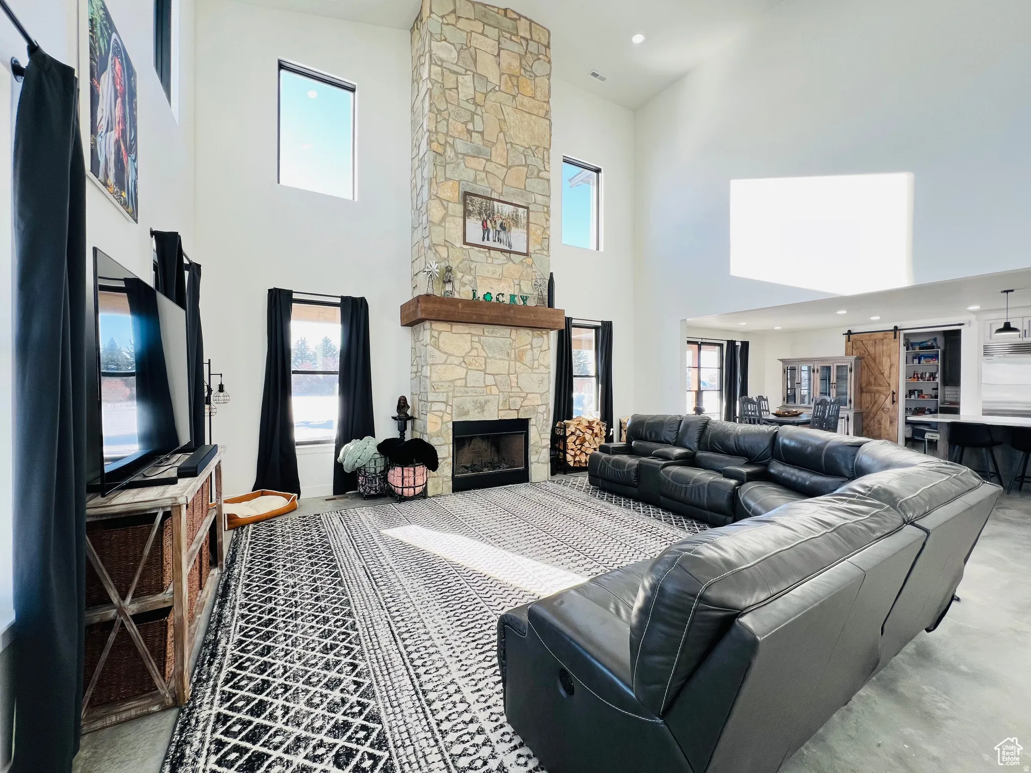 Living area with a high ceiling, a fireplace, and recessed lighting