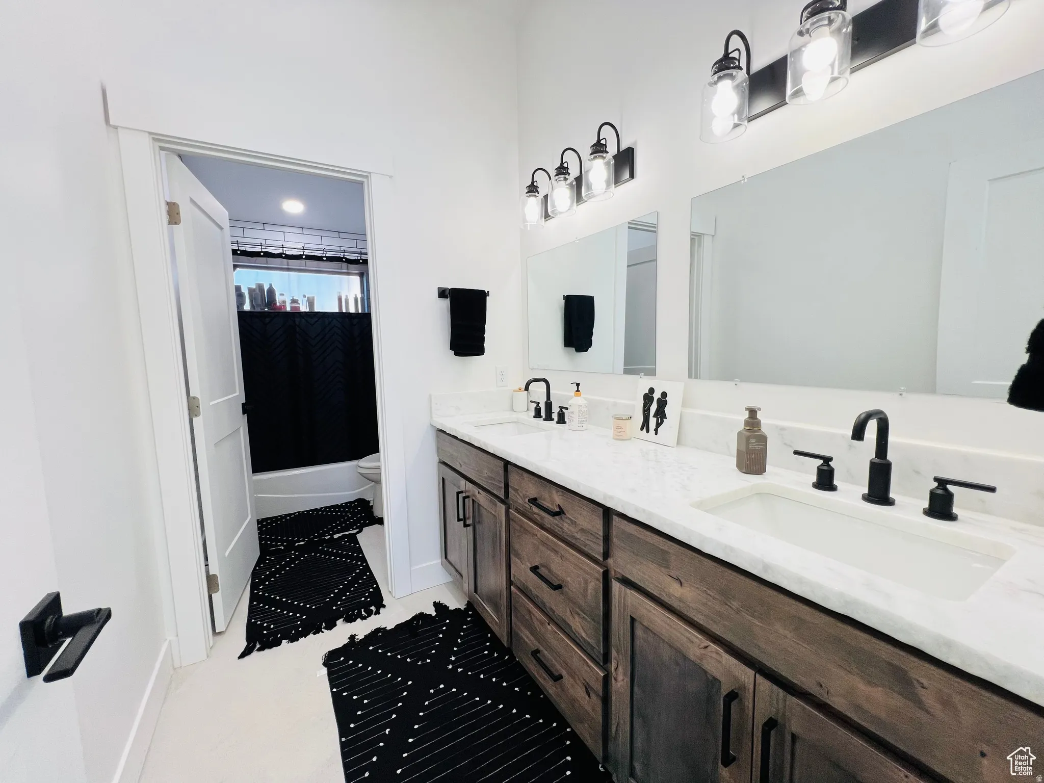 Bathroom with double vanity and shower / bath combination with curtain