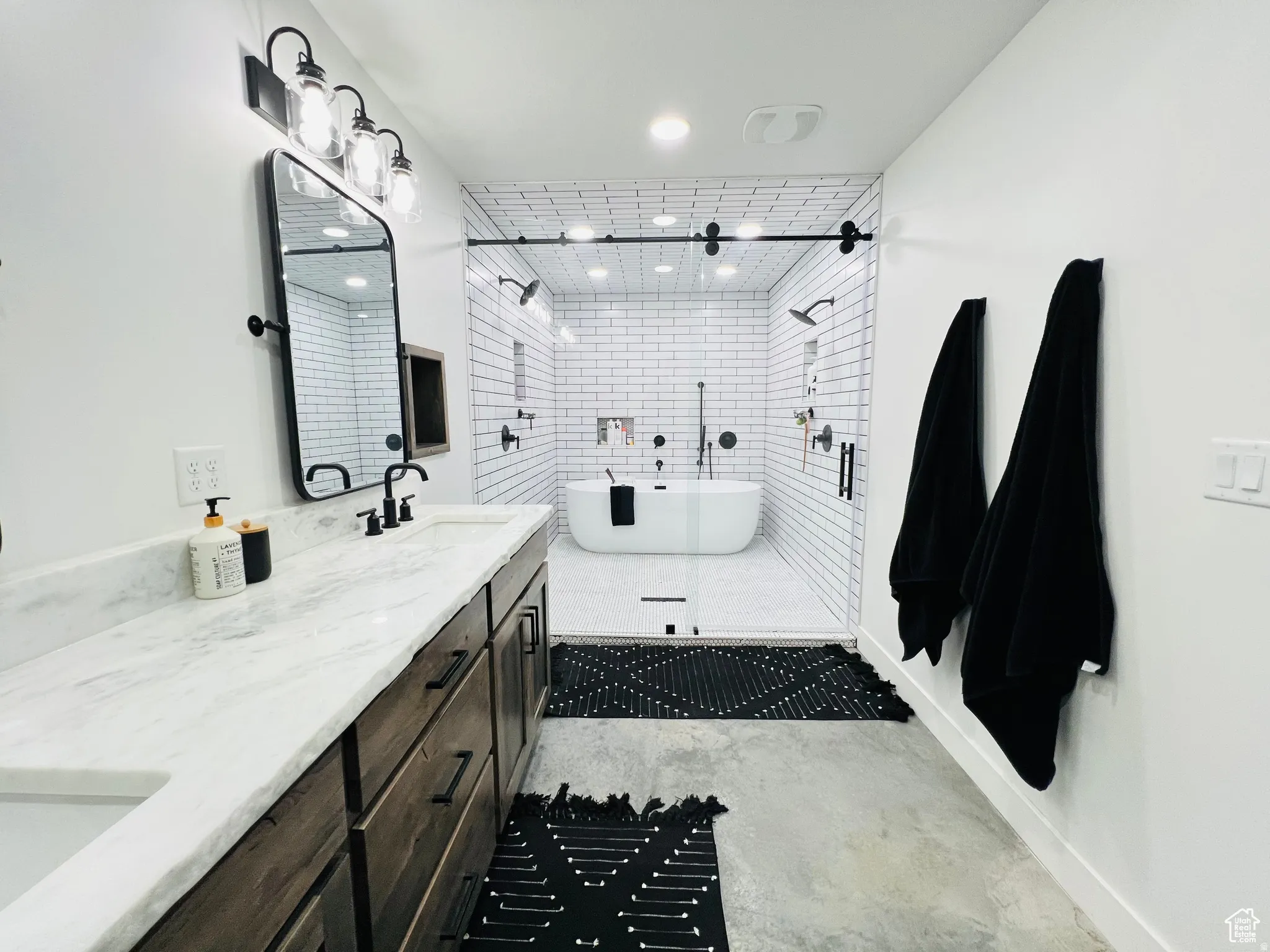 Bathroom with double vanity, a soaking tub, and a stall shower