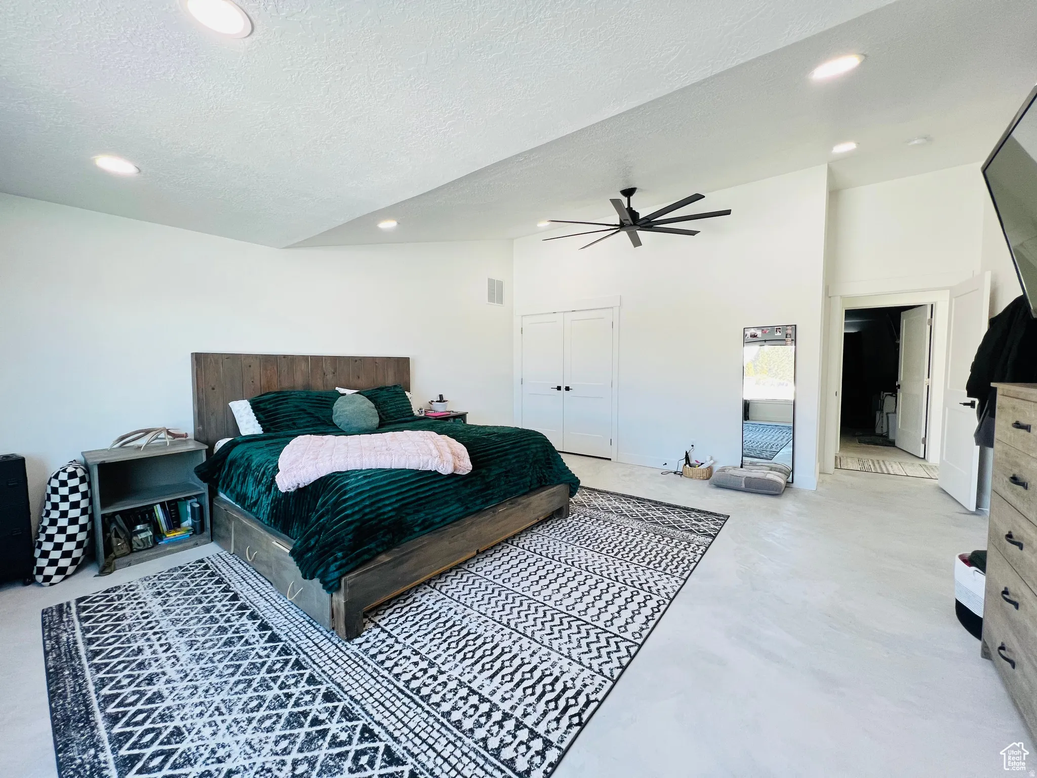 Bedroom with a ceiling fan, a closet, recessed lighting, a textured ceiling, and concrete flooring