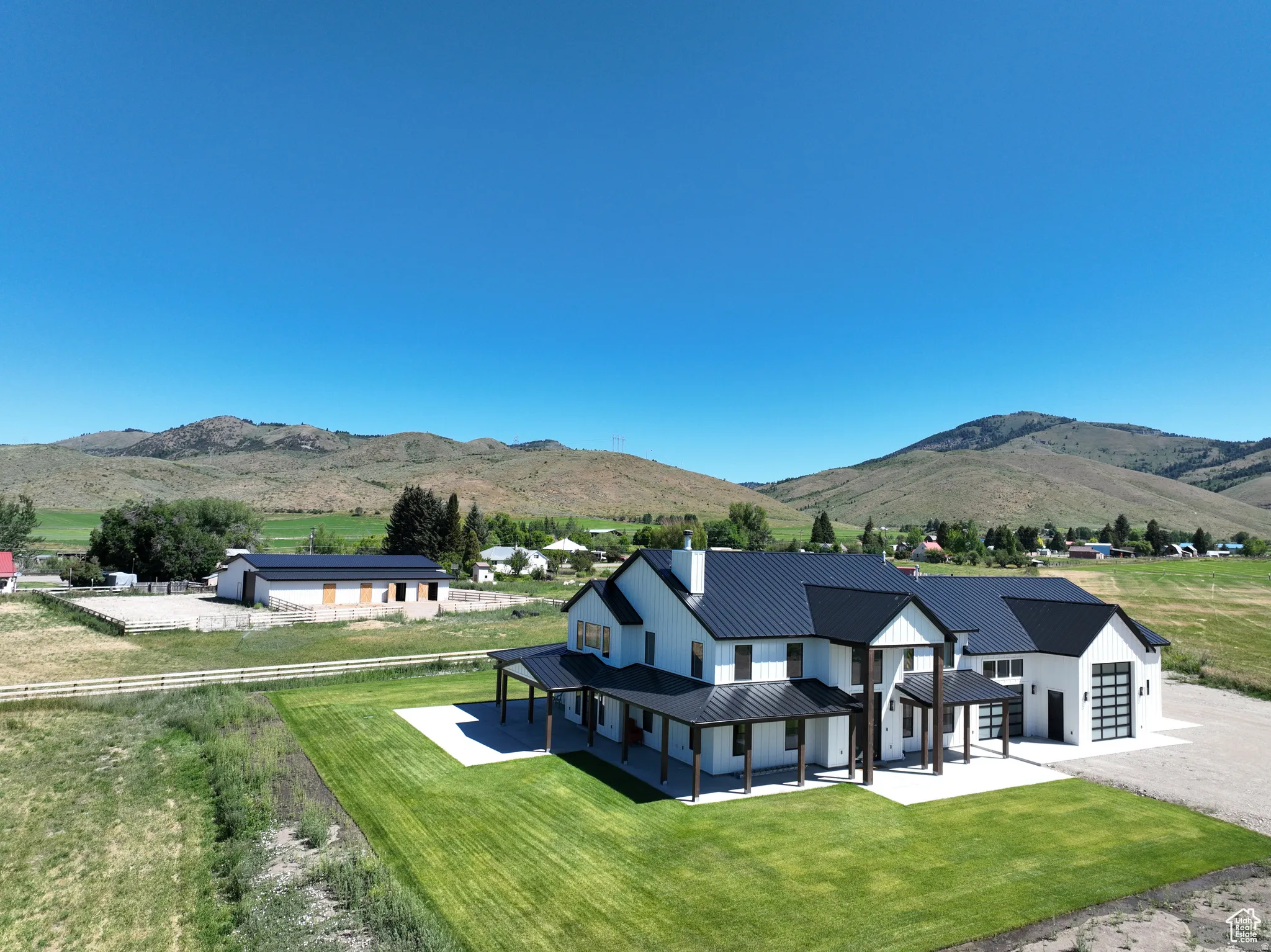 Rear view of house featuring a yard, a mountain view, a chimney, and a garage