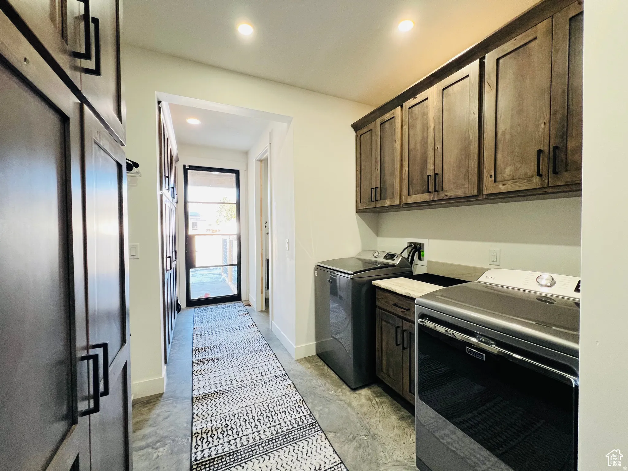 Laundry area featuring cabinet space, separate washer and dryer, and recessed lighting