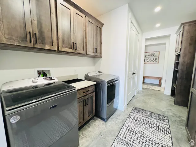 Laundry room featuring separate washer and dryer, recessed lighting, and cabinet space