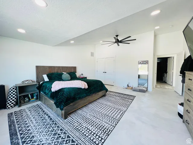 Bedroom with a ceiling fan, a closet, recessed lighting, a textured ceiling, and concrete flooring