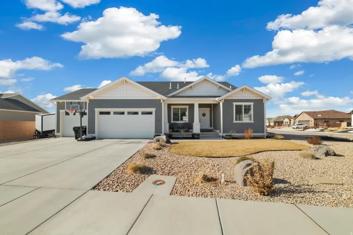 View of front of property with a porch, an attached garage, and concrete driveway