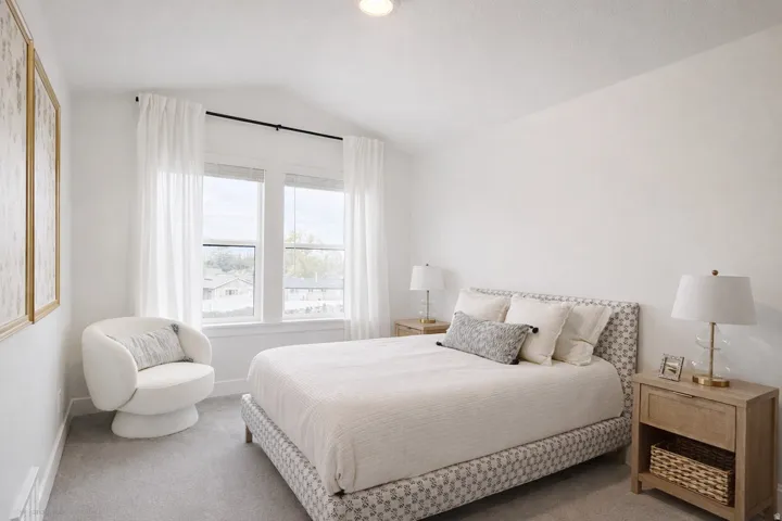 Bedroom with vaulted ceiling and carpet