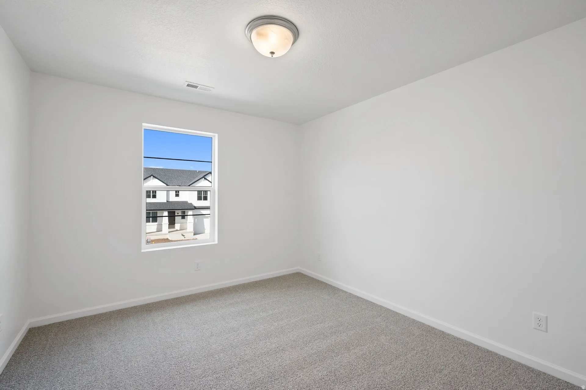 Secondary bedroom with baseboards and light-colored carpet