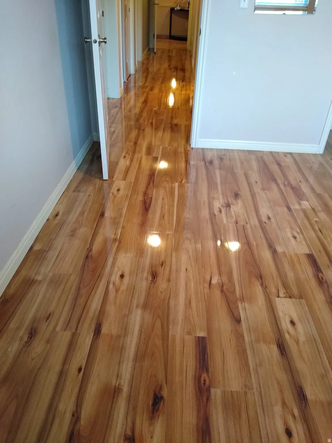 Corridor featuring light wood-style flooring and baseboards