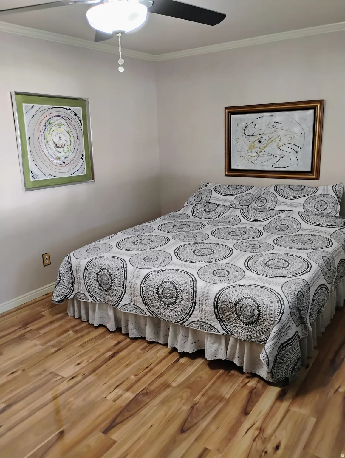 Bedroom with ornamental molding, light wood-style flooring, and ceiling fan