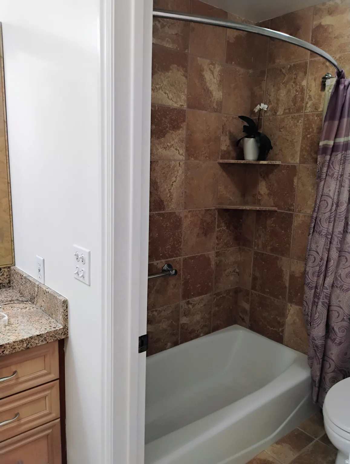 Bathroom with vanity, shower / tub combo, and tile patterned floors