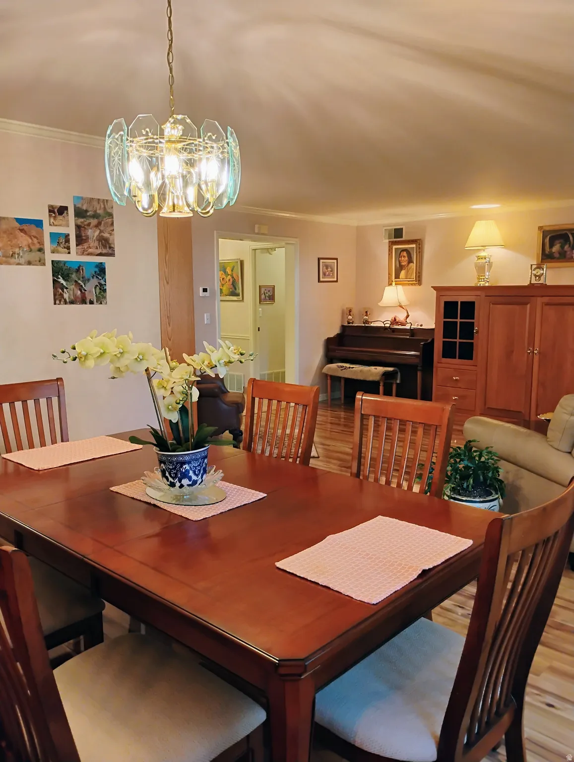 Dining area featuring a chandelier, light wood-style floors, and ornamental molding