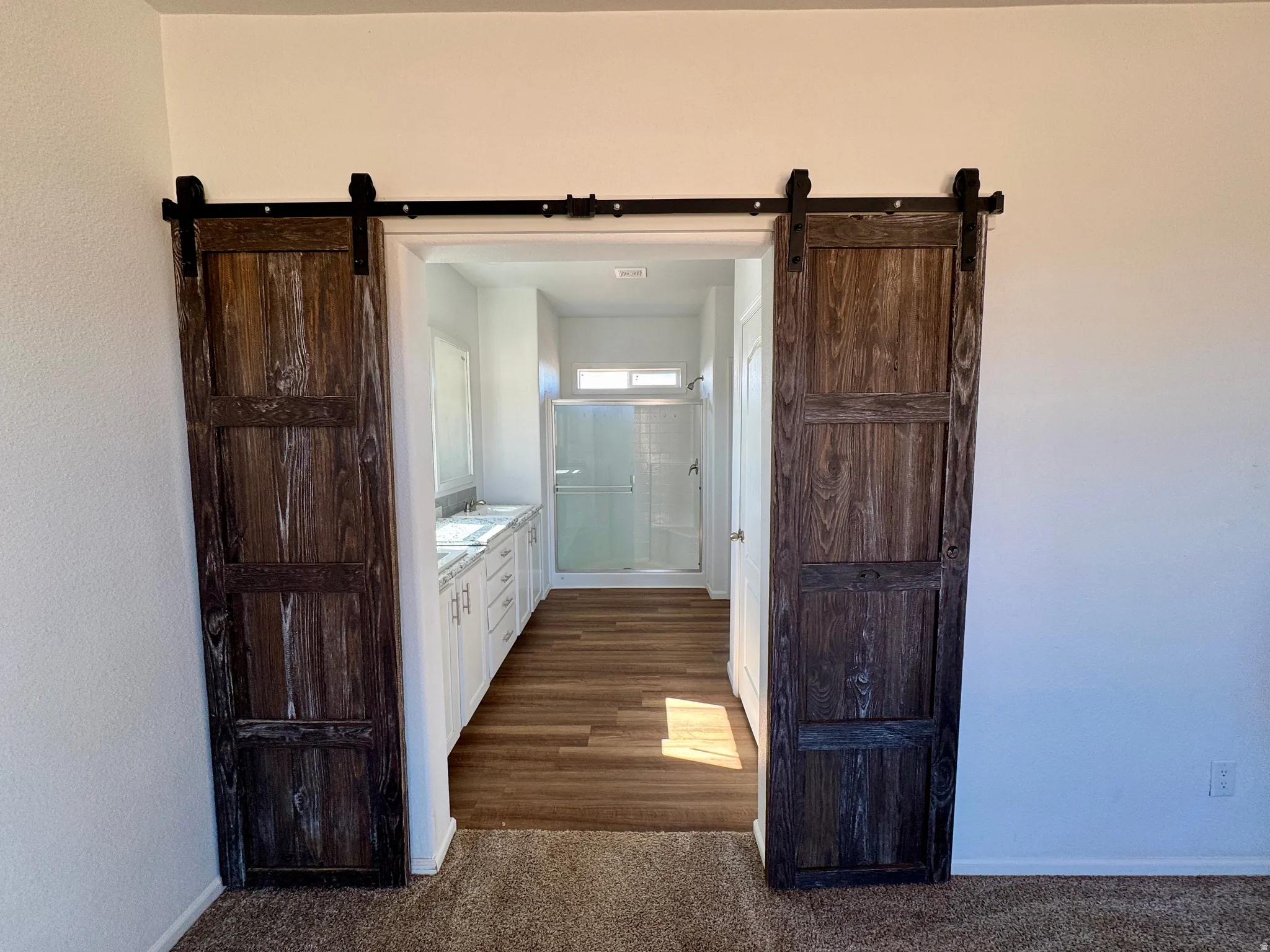 Ensuite bathroom featuring a stall shower and double sinks.