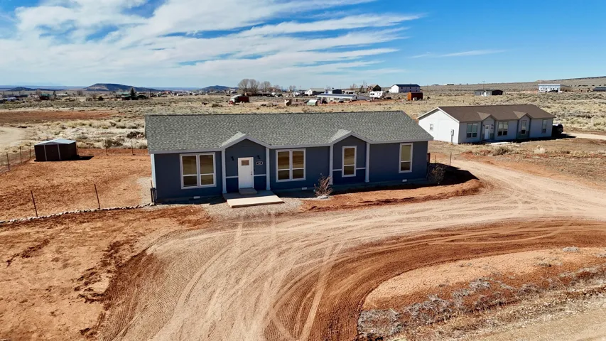 Single story home with a mountain view, view of desert landscape, and a shingled roof