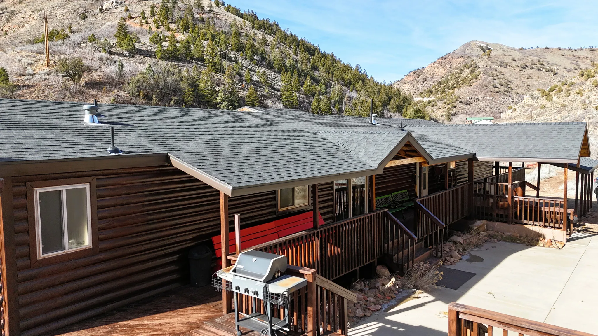 Back of house with a shingled roof and a deck with mountain view
