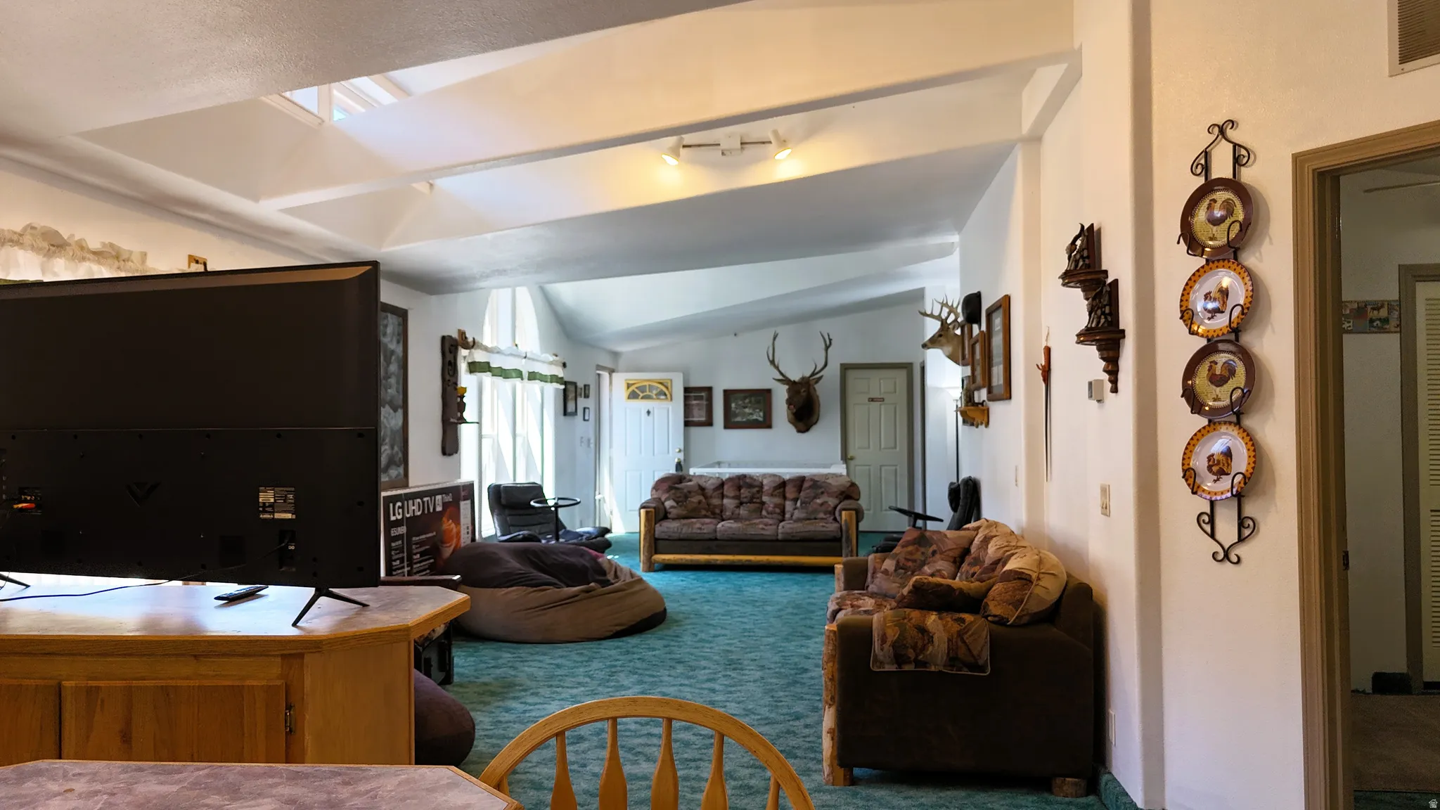 Carpeted living room featuring vaulted ceiling