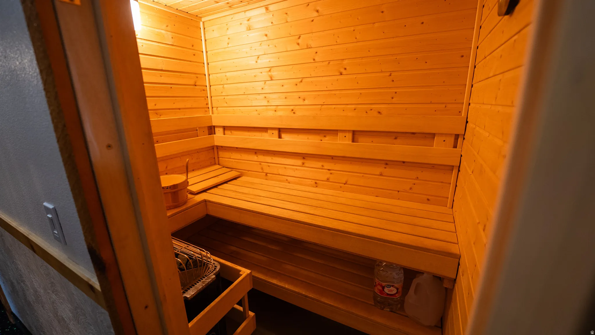 Custom-built sauna with all-wood interior paneling, tiered wood benches, and a built-in heater