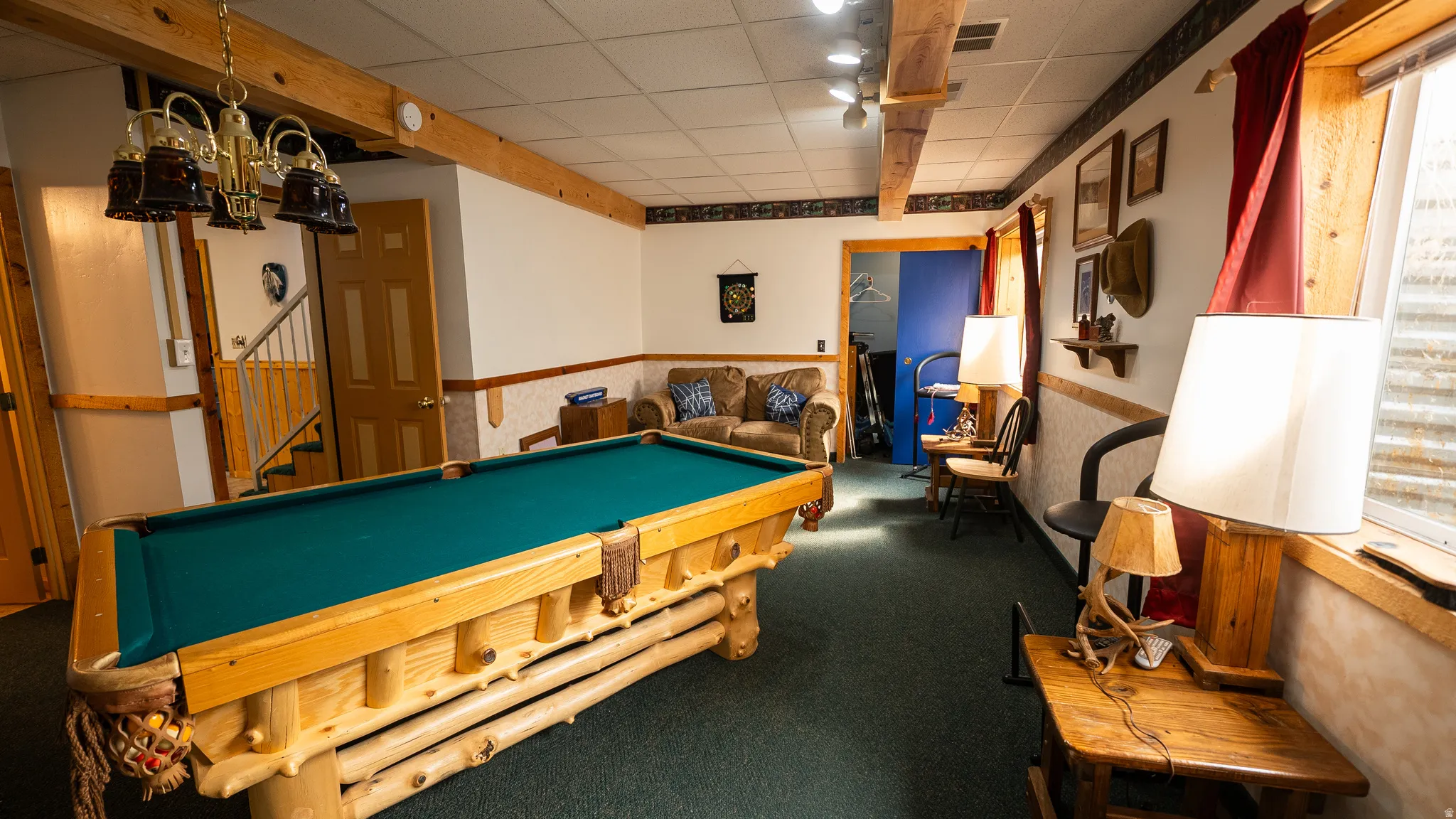 Recreational room with carpet flooring and exposed wood beams