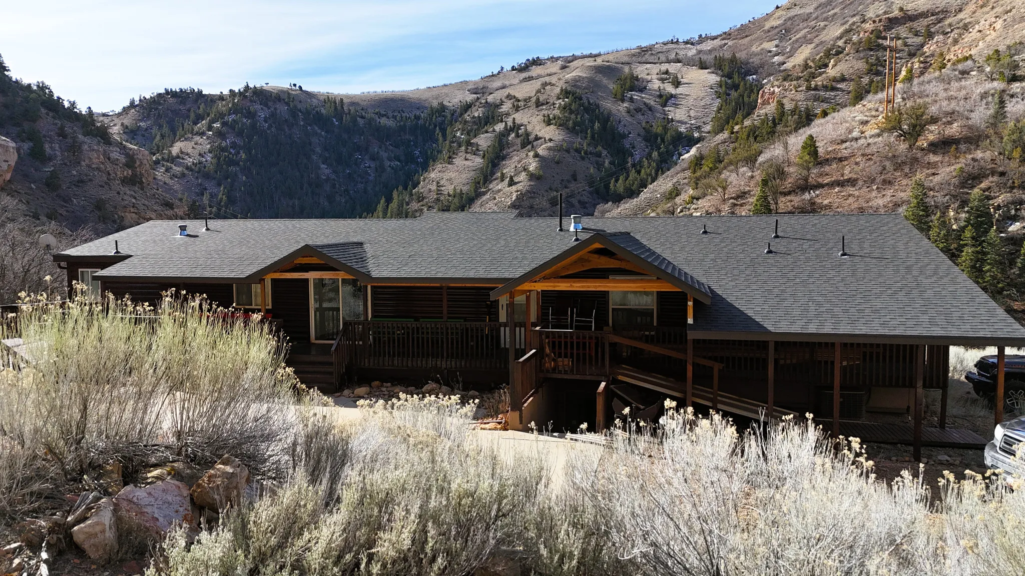 Back of property featuring a shingled roof and a deck with mountain view