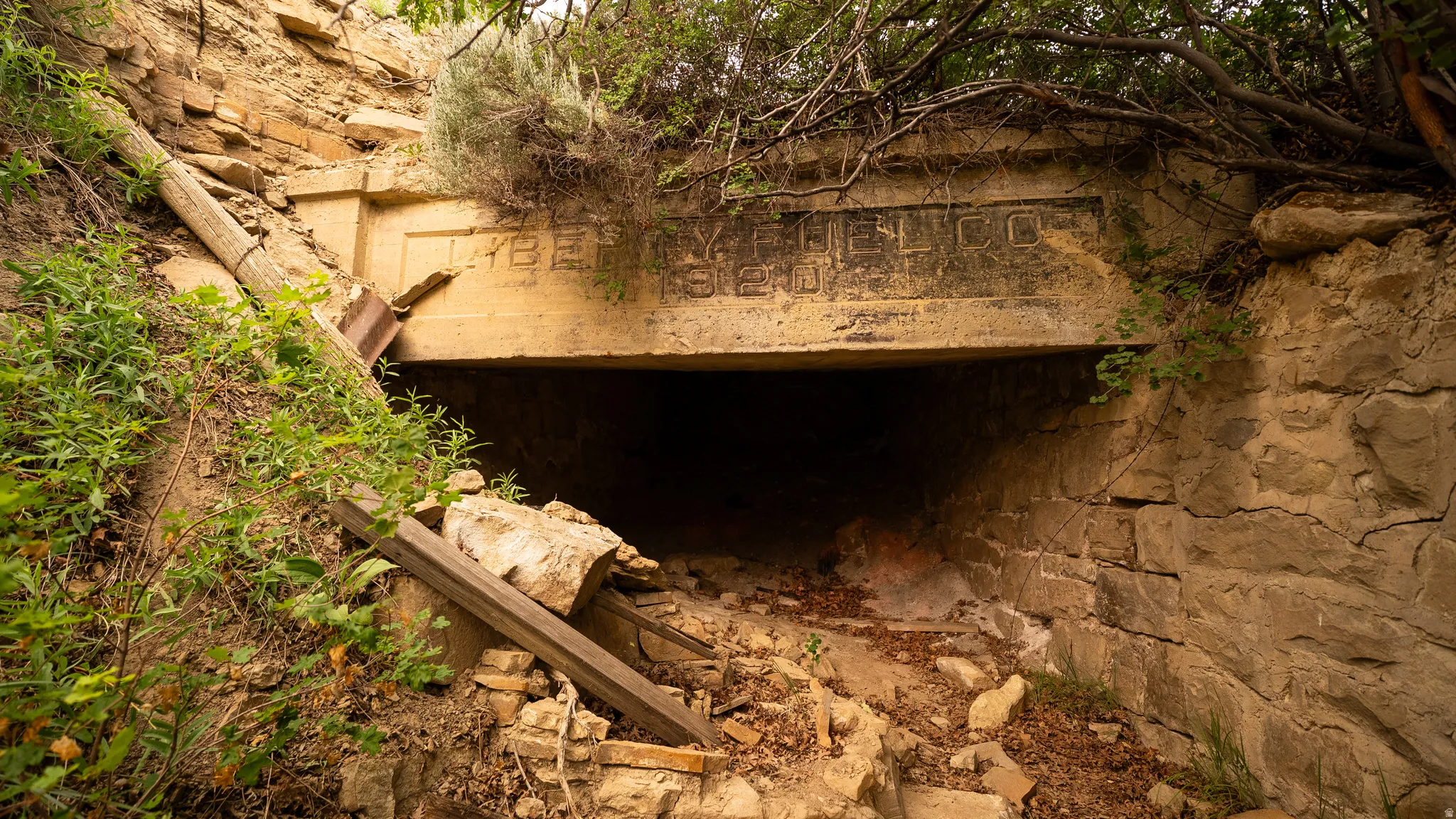 Concrete tunnel entrance with stone block retaining walls and a dirt path