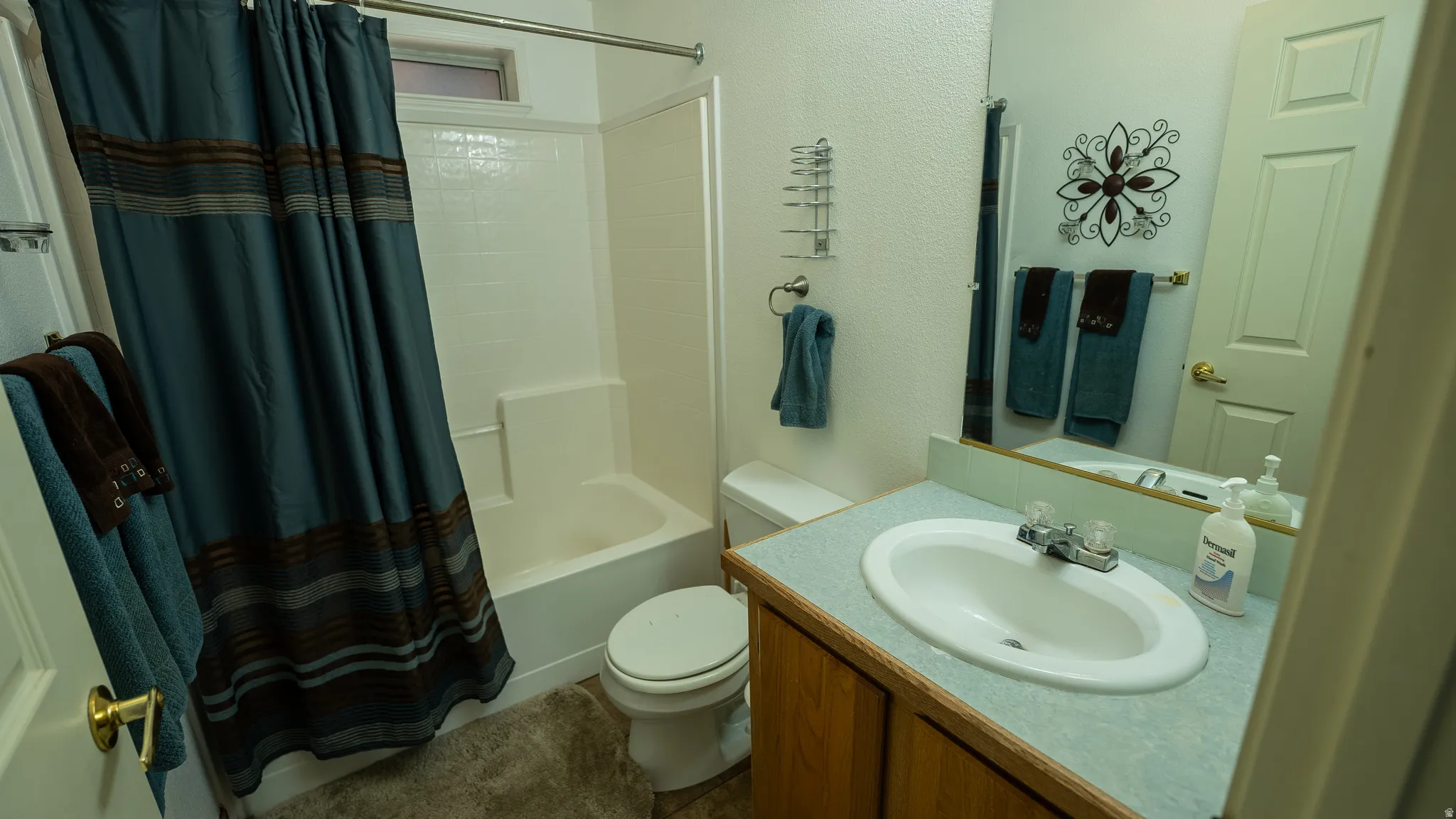 Full bathroom featuring a white tub/shower combination with a textured surround