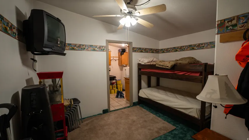 Room featuring a bunk bed, ceiling fan, and wall-mounted television