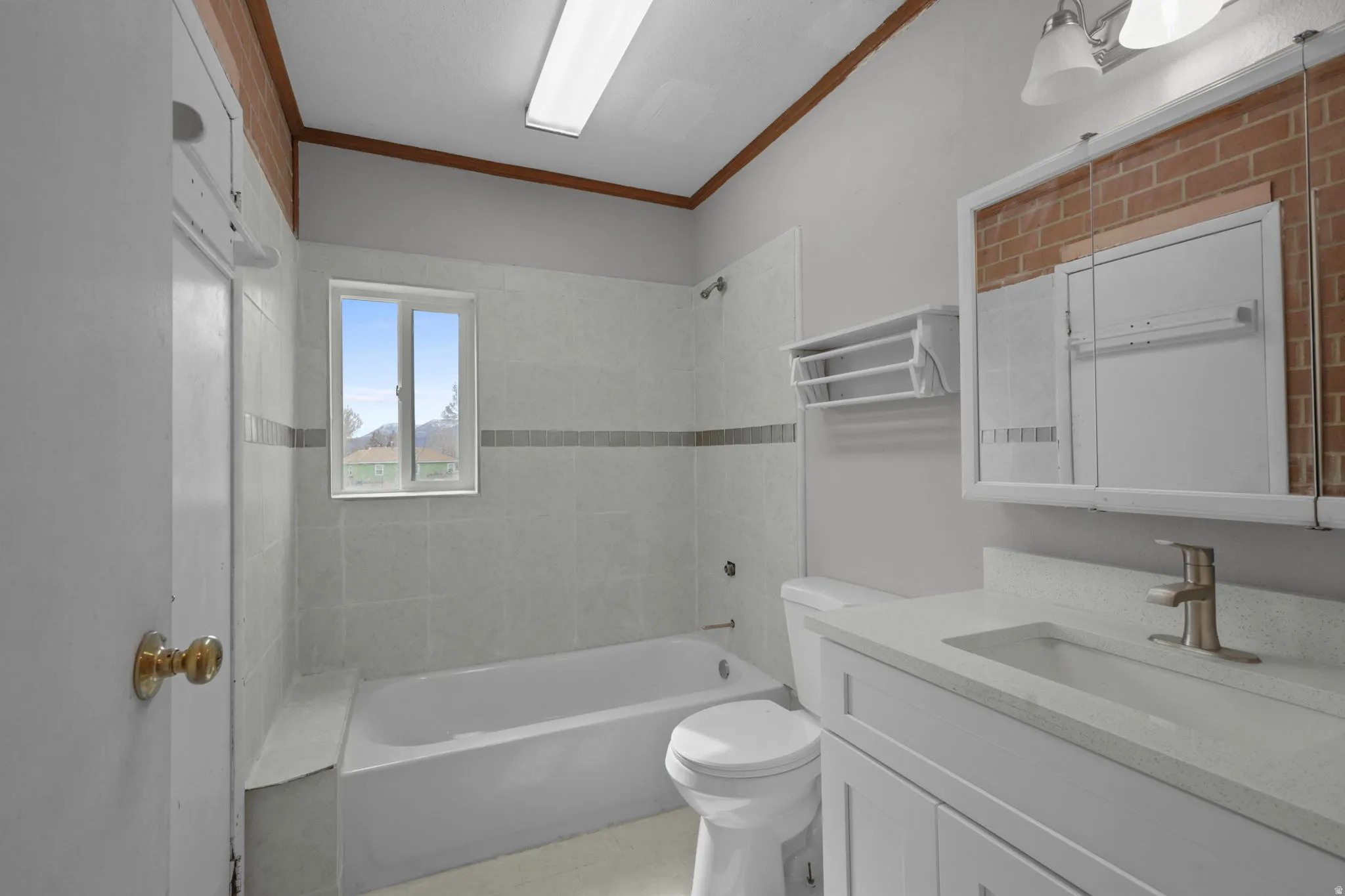 Bathroom with vanity, shower / bath combination, and crown molding