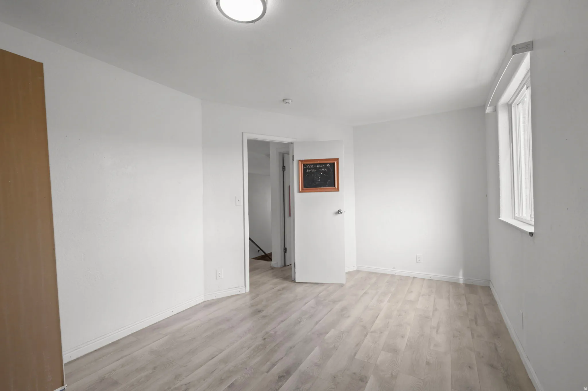 Empty room with light wood-style flooring and baseboards