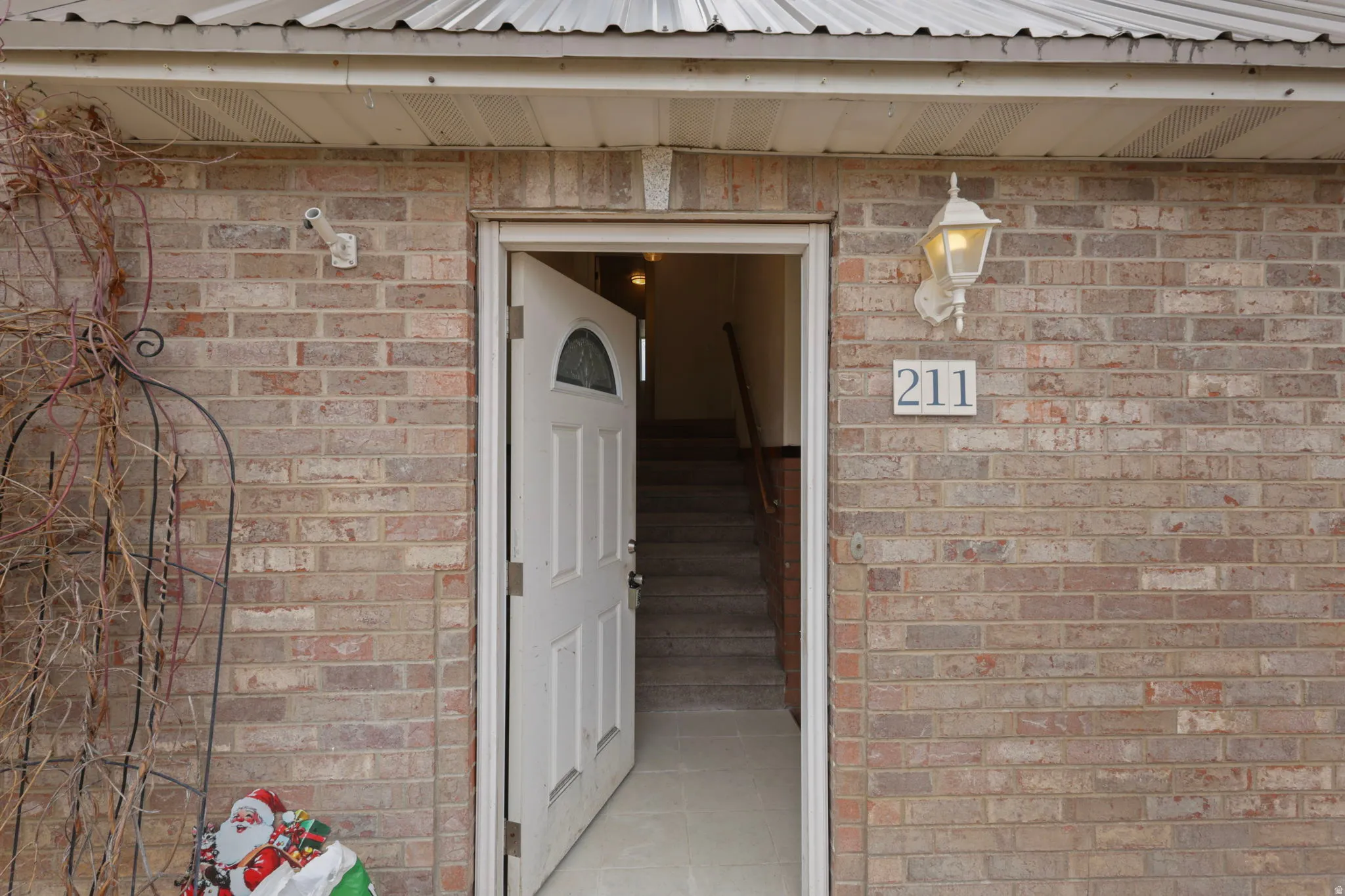 View of exterior entry with brick siding and a metal roof
