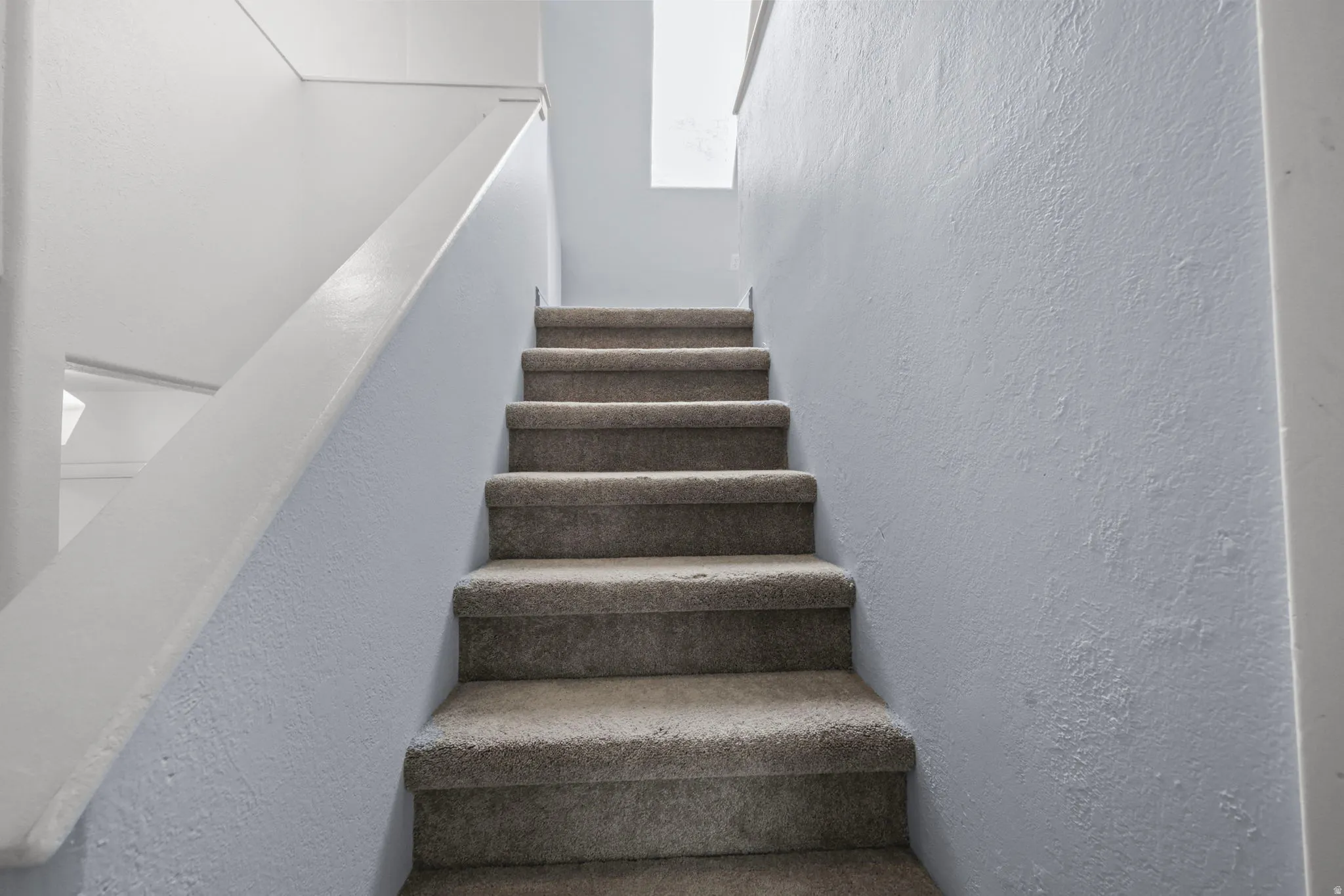 Stairs featuring a textured wall