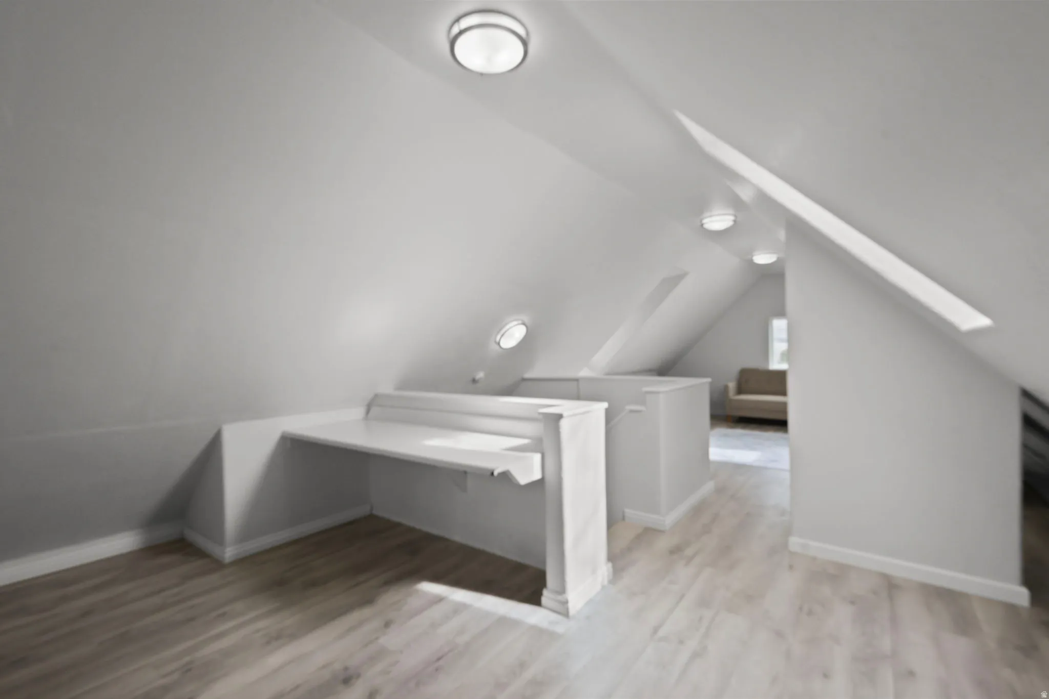 Bonus room with a skylight, light wood-type flooring, and vaulted ceiling