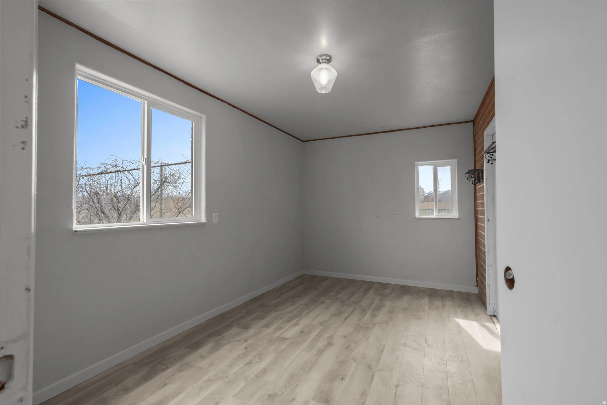 Unfurnished room with light wood finished floors and crown molding
