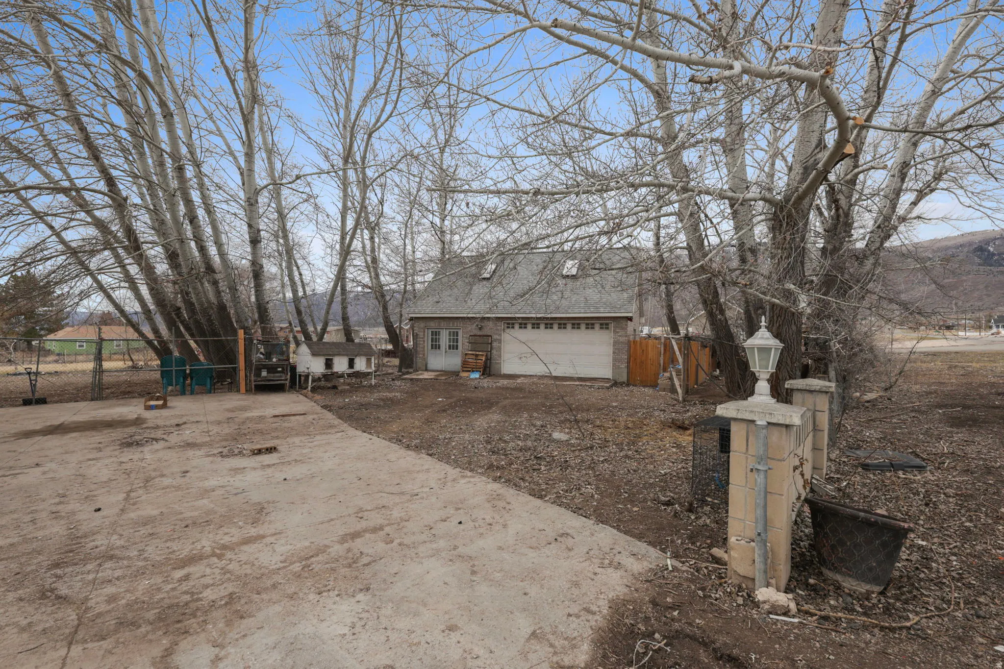 View of side of property with a garage and dirt driveway