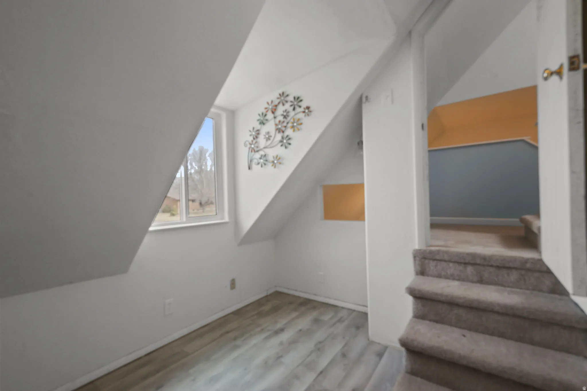 Bonus room featuring light wood-type flooring and vaulted ceiling
