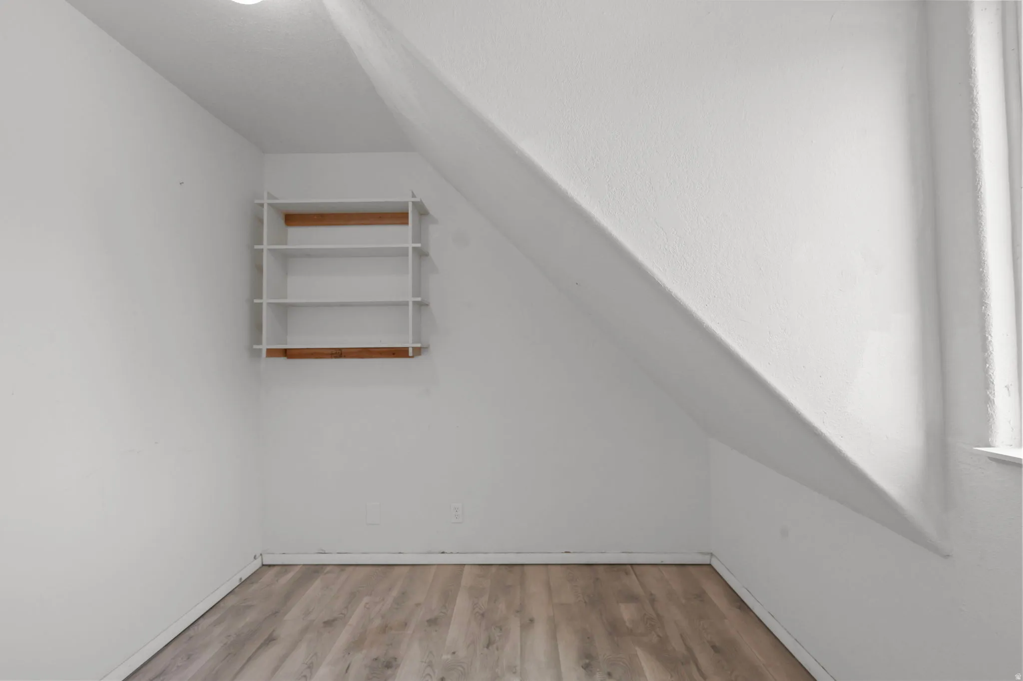 Bonus room featuring vaulted ceiling and light wood-style floors