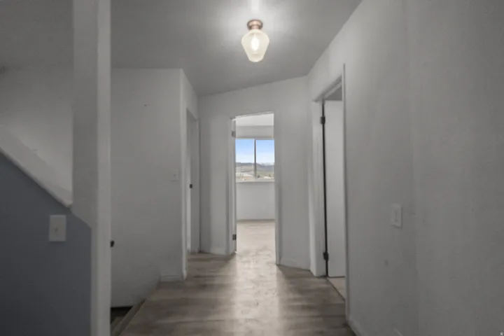 Hallway with wood finished floors and baseboards