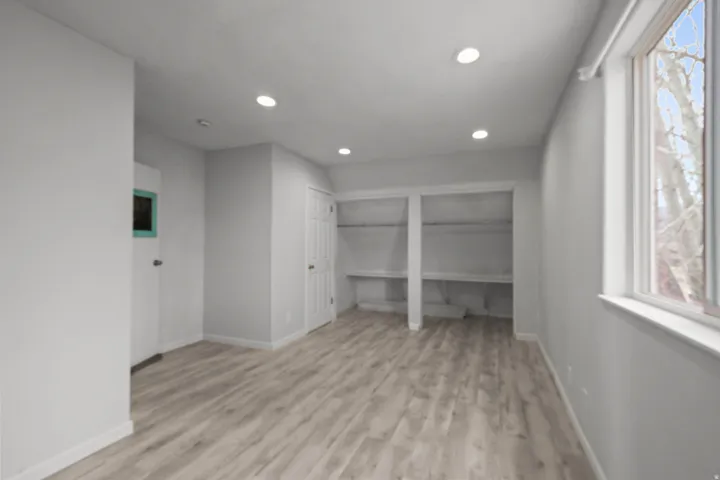 Unfurnished bedroom with multiple closets, light wood-style flooring, and recessed lighting