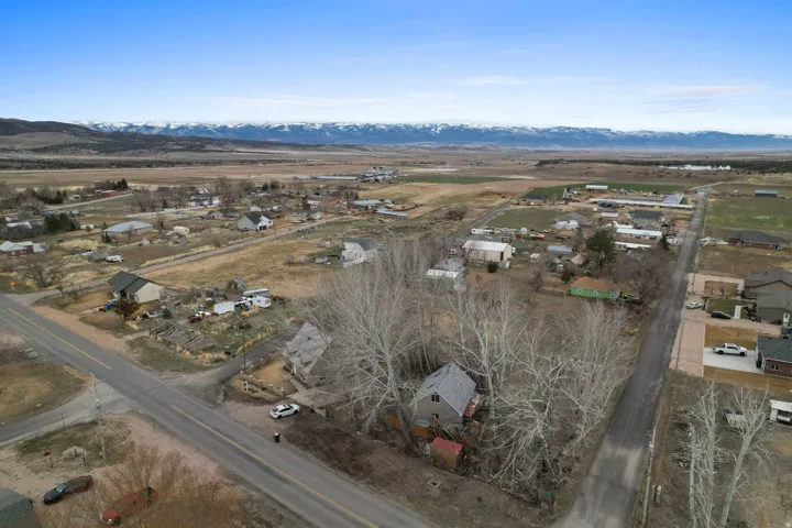 Aerial overview of property's location with a mountain backdrop and nearby suburban area