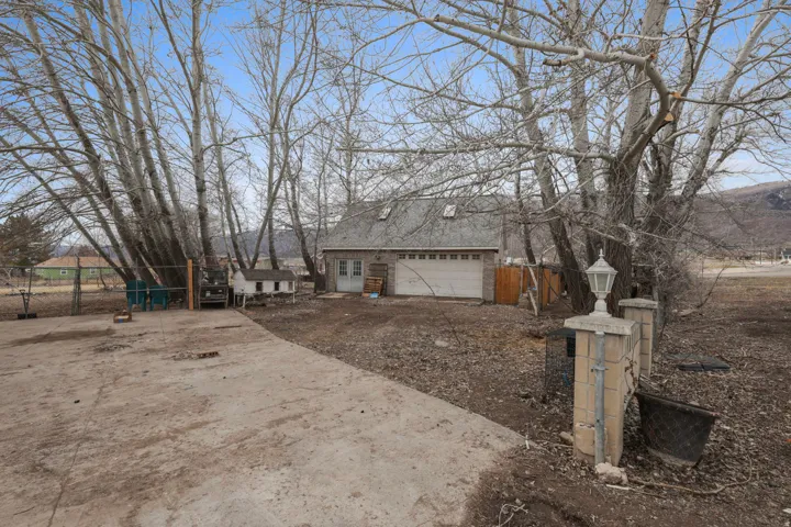 View of side of property with a garage and dirt driveway