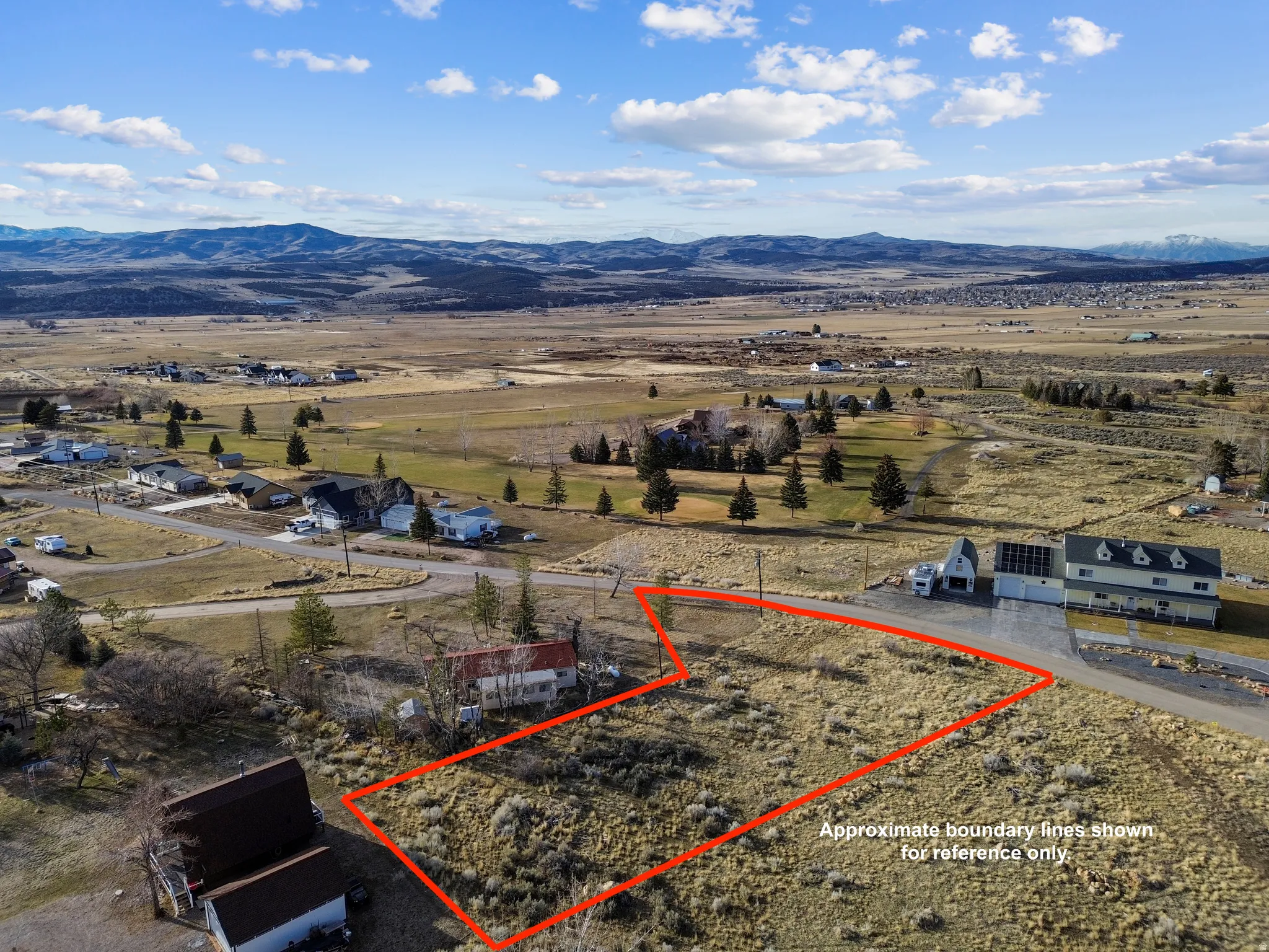 Aerial view of sparsely populated area featuring property parcel outlined and a mountain backdrop