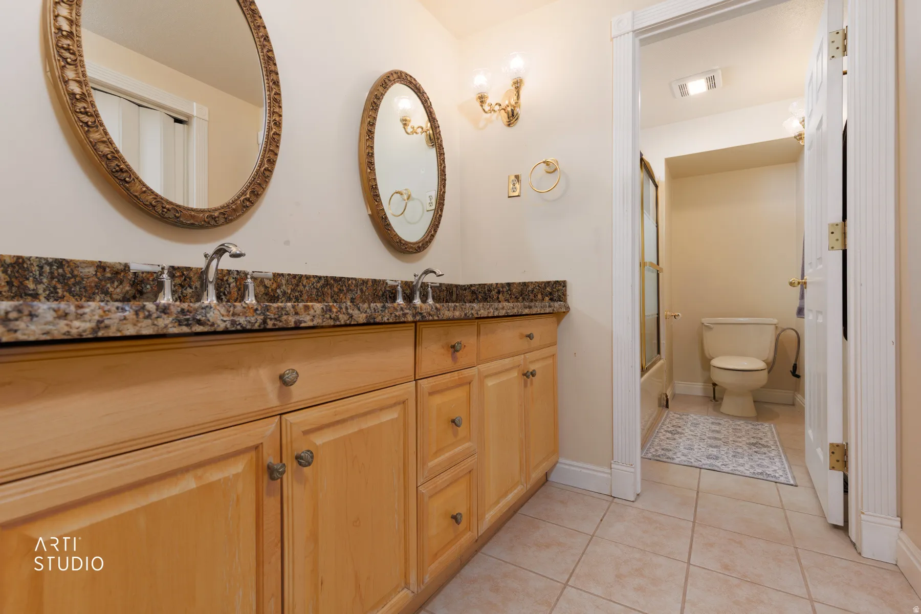 Bathroom with double vanity and light tile patterned flooring