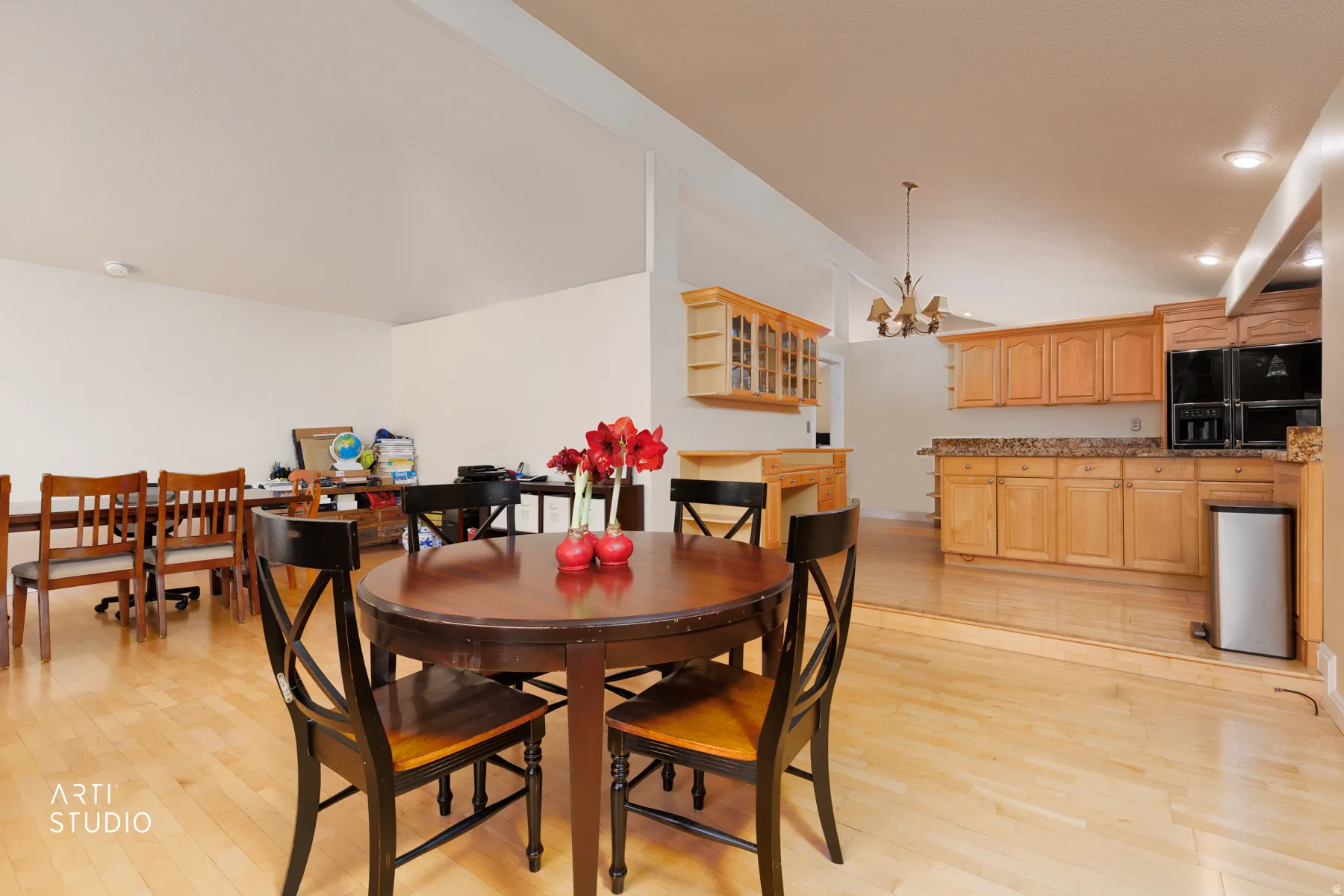 Dining space with light wood finished floors and hanging lights