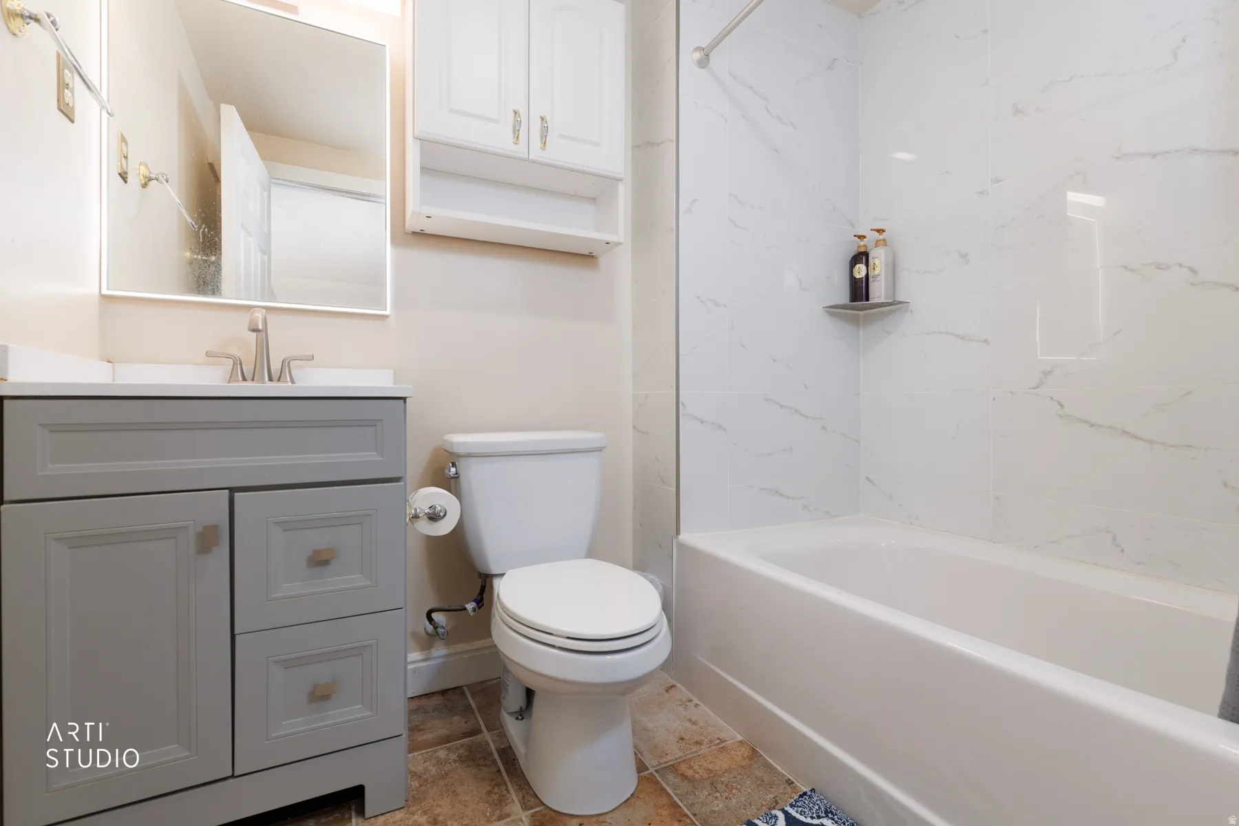 Bathroom featuring vanity and washtub / shower combination