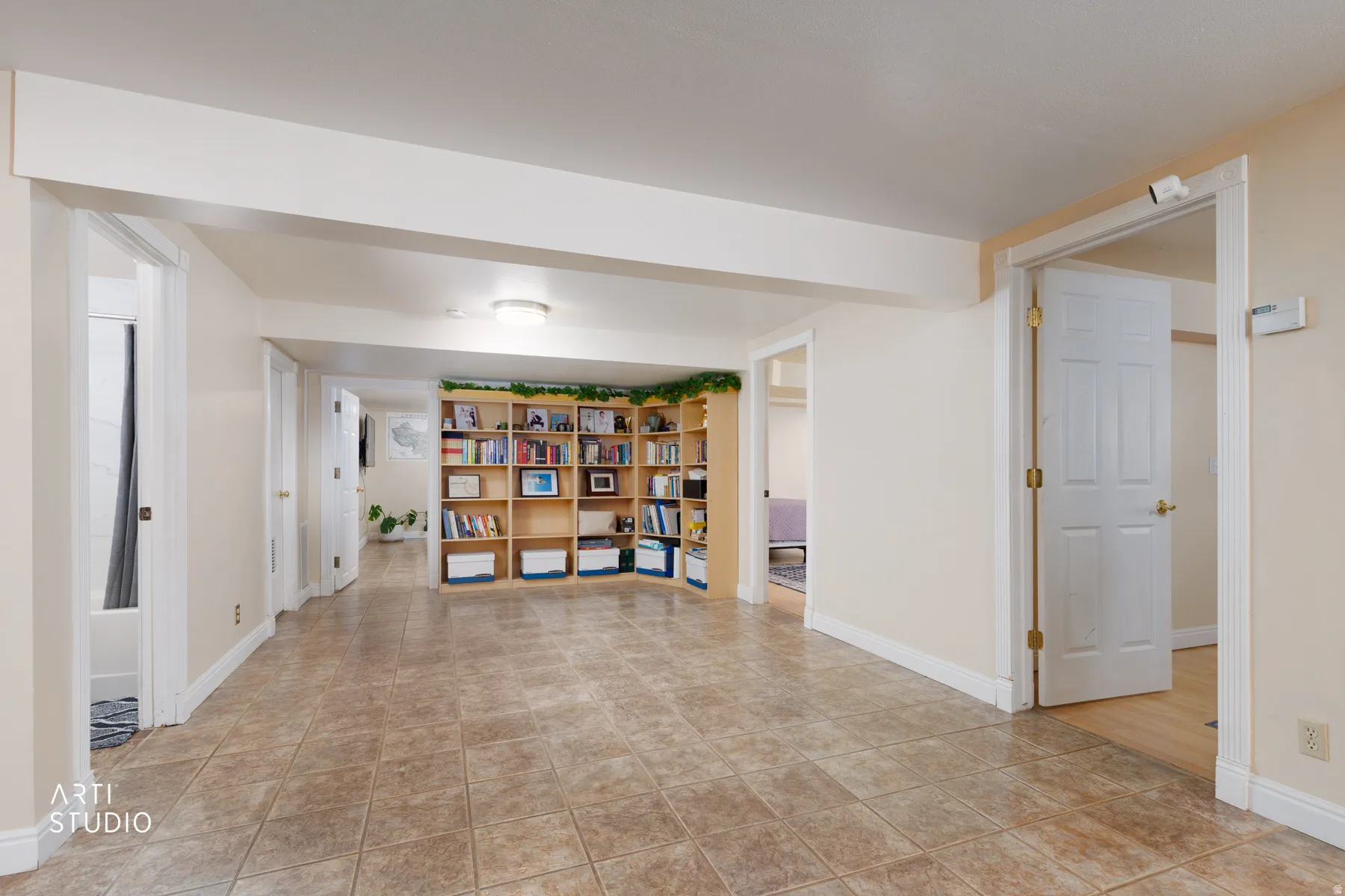 Hallway with baseboards and light tile patterned floors