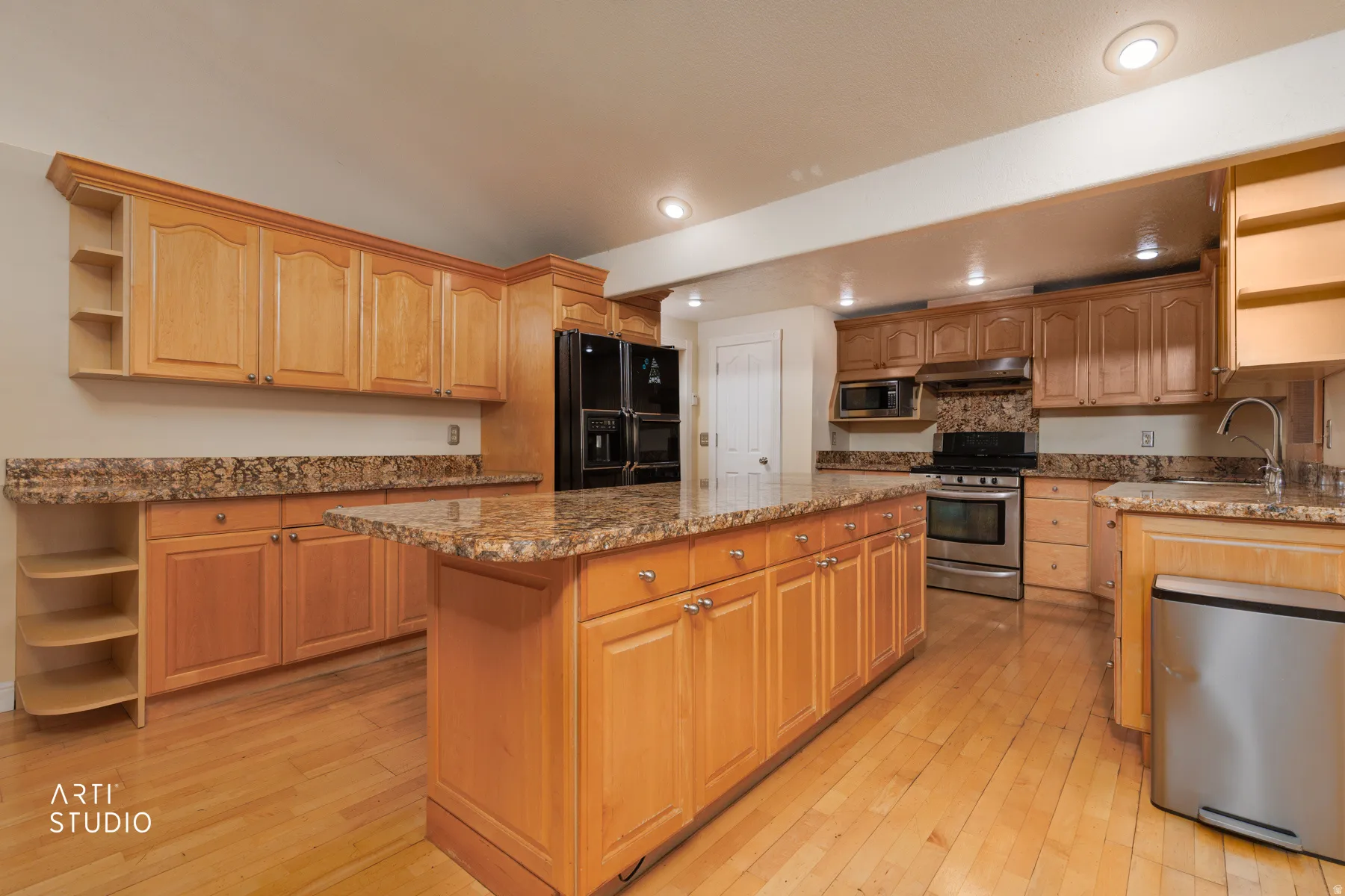 Kitchen featuring open shelves, stainless steel appliances, dark stone counters, a kitchen island, and recessed lighting