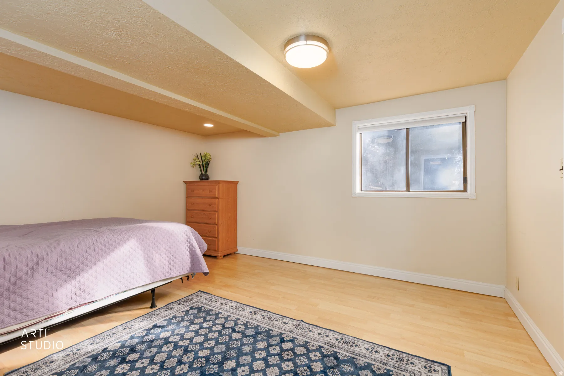 Bedroom with light wood-type flooring and a textured ceiling