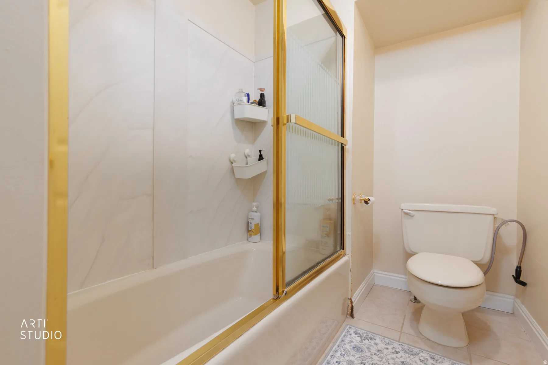 Full bathroom featuring light tile patterned floors and shower / bath combination with glass door